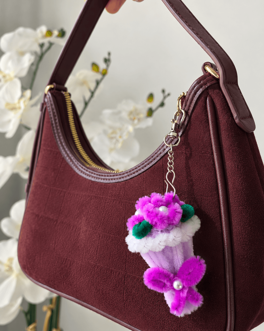 Bloom Cup Keychain โ A cute handmade floral keychain featuring a soft lavender cup-style charm, bright pink flowers, green leaf details, pearl-style accents, and a matching dangling flower. Perfect for handbags, backpacks, purses, and gifting. (detail angle)