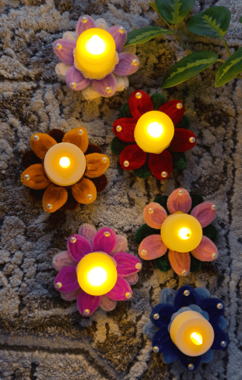 Festive Bloom LED Holder โ A colorful handmade floral diya holder featuring soft pipe-cleaner petals, pearl-style accents, and a warm LED tealight center. Perfect for Diwali, festive tables, pooja decor, rangoli arrangements, and gifting.